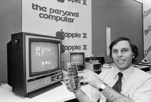 B&W photo of businessman in store holding Apple II peripheral